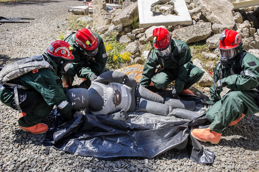 Airmen load a medical mannequin into a collection bag during training at Camp Rilea, Warrenton, Ore., Aug. 4, 2016. The airmen, assigned to the Colorado National Guard’s 140th Fatality Search and Rescue Team, function as a recovery team, helping families find closure after properly identifying those who have lost their lives. Air National Guard photo by Staff Sgt. Bobbie Reynolds