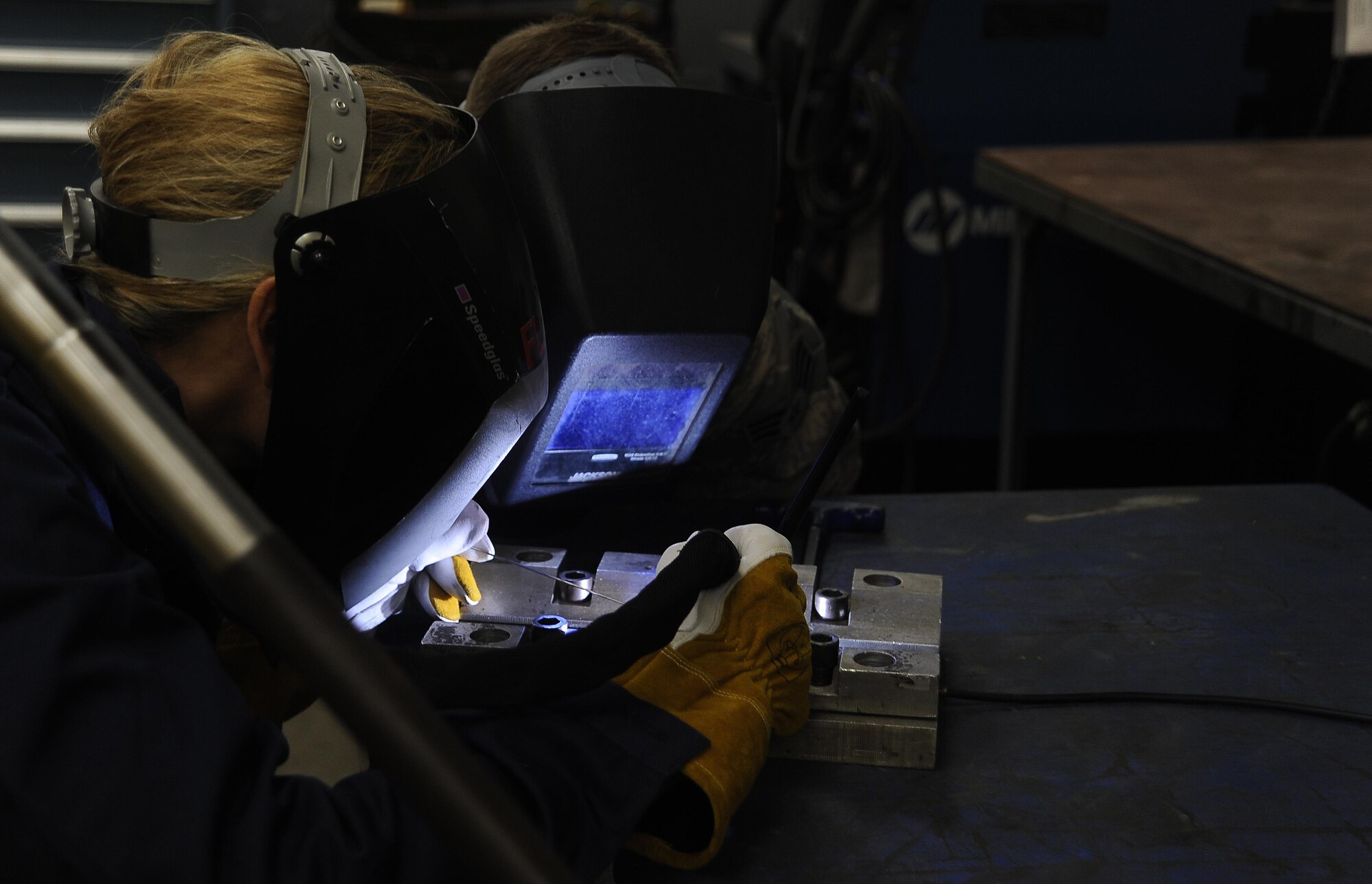 Col. April Vogel, left, commander of the 6th Air Mobility Wing, welds a stainless steel plate with the assistance of Senior Airman Tyler Treadaway, right, an aircraft metals technology technician with the 6th Maintenance Squadron, during Airmen’s Time, Aug. 11, 2016, at MacDill Air Force Base, Fla. Vogel practiced gas tungsten arc welding on a stainless steel plate. (U.S. Air Force photo by Airman 1st Class Mariette Adams)