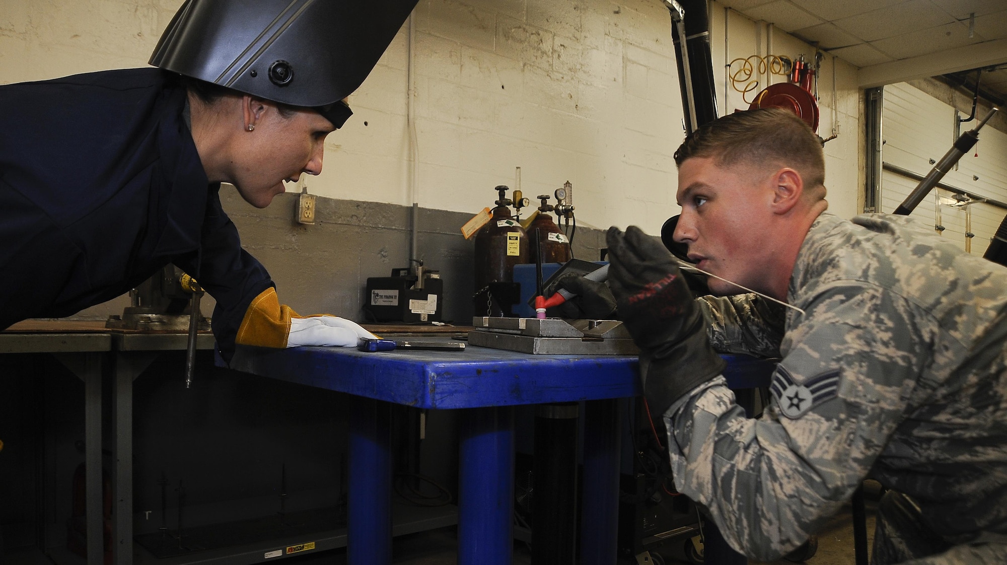 Col. April Vogel, left, commander of the 6th Air Mobility Wing, learns how to weld from Senior Airman Tyler Treadaway, right, an aircraft metals technology technician with the 6th Maintenance Squadron, Aug. 11, 2016, during Airmen’s Time at MacDill Air Force Base, Fla. Vogel practiced gas tungsten arc welding on a stainless steel plate. (U.S. Air Force photo by Airman 1st Class Mariette Adams)