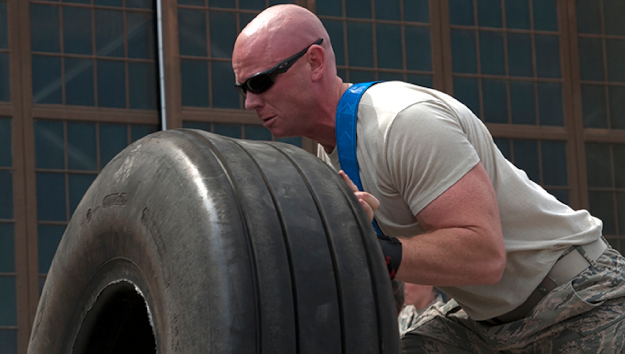 Staff Sgt. Andrew Lesperance, 92nd Maintenance Group quality assurance inspector, heaves a KC-135 landing gear tire end-over-end in the Fairchild MXG Olympic Relay Competition Aug. 5, 2016, at Fairchild Air Force Base, Wash. The tires, which weigh approximately 200-250 pounds each, were the obstacle in the first leg of the four-part relay race. (U.S. Air Force photo/Airman 1st Class Ryan Lackey)