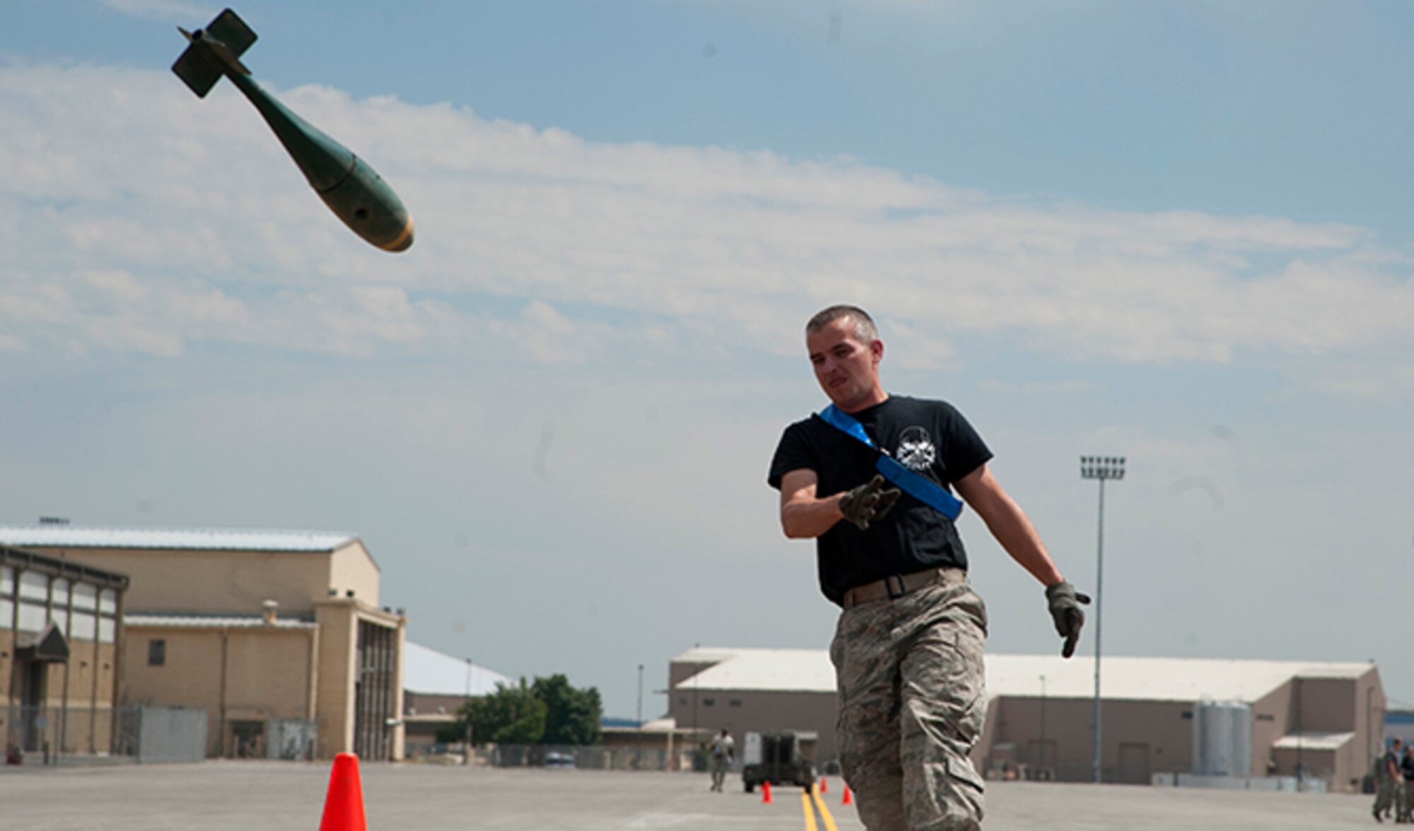 Tech. Sgt. Bradly Alberts, 141st Maintenance Group quality assurance inspector, hurls a dummy bomb munition weighing approximately 25-30 pounds during the Fairchild MXG Olympic Relay Competition Aug. 5, 2016, at Fairchild Air Force Base, Wash. The last leg of the four-part relay directly followed a quarter mile sprint across the flight line to finish with the bomb toss. (U.S. Air Force photo/Airman 1st Class Ryan Lackey)