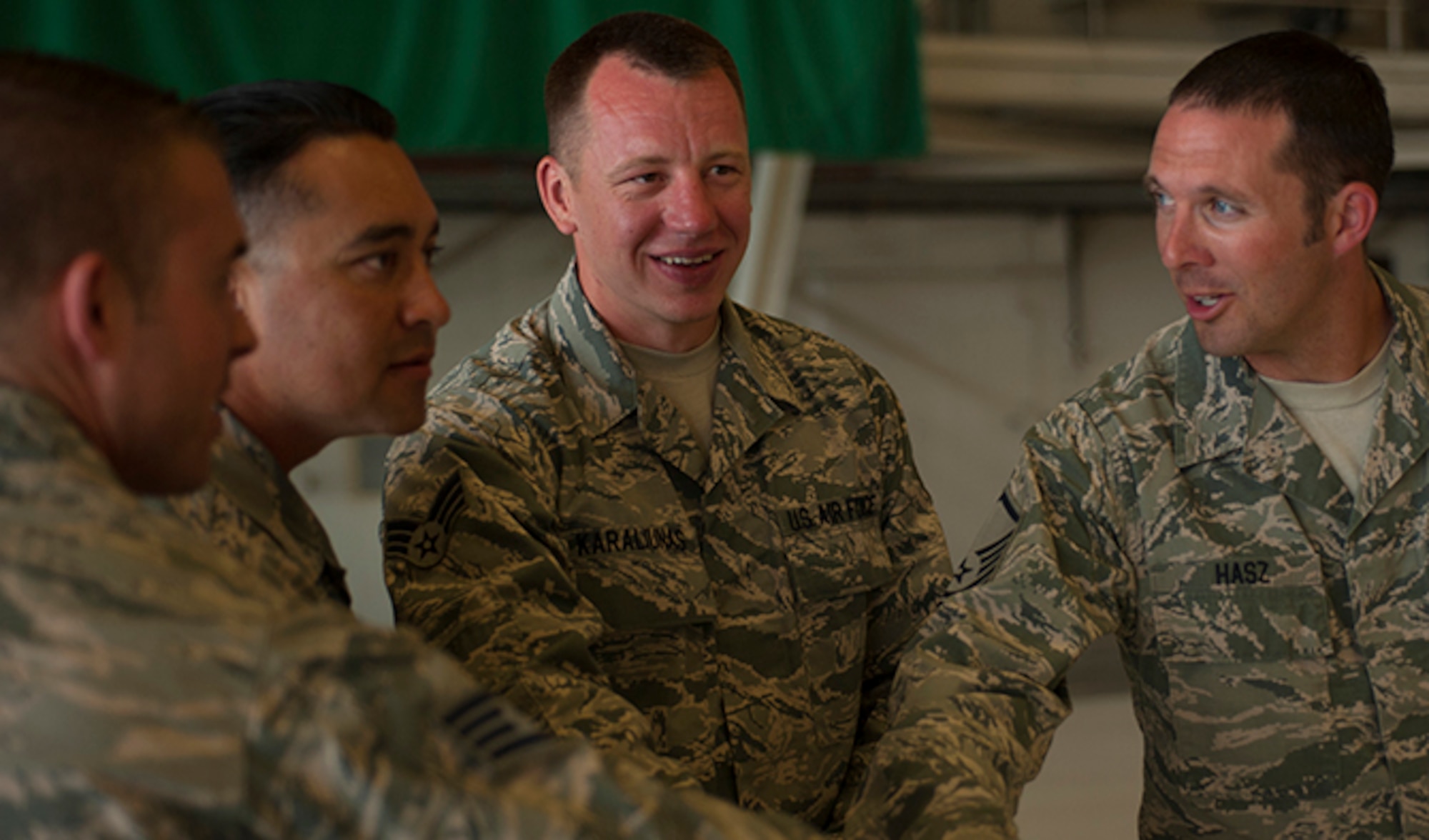 Fairchild Maintenance Group Olympic Relay Competition winners, (from left to right) Staff. Sgt. Robert Goodman, 92nd MXG Aircraft General flying crew chief, Master Sgt. Dominik Gutierrez, 92nd MXG Aircraft General flight line Expediter, Senior Airman Milvydas Karaliunas, 92nd MXG flight line expediter and MSgt Lance Hasz, 92nd MXG flight line production supervisor huddle up in celebration Aug. 5, 2016, at Fairchild Air Force Base, Wash. The winning Airmen expressed a desire to see more events like this one and look forward to participating in more competitions. (U.S. Air Force photo/ Airman 1st Class Ryan Lackey)