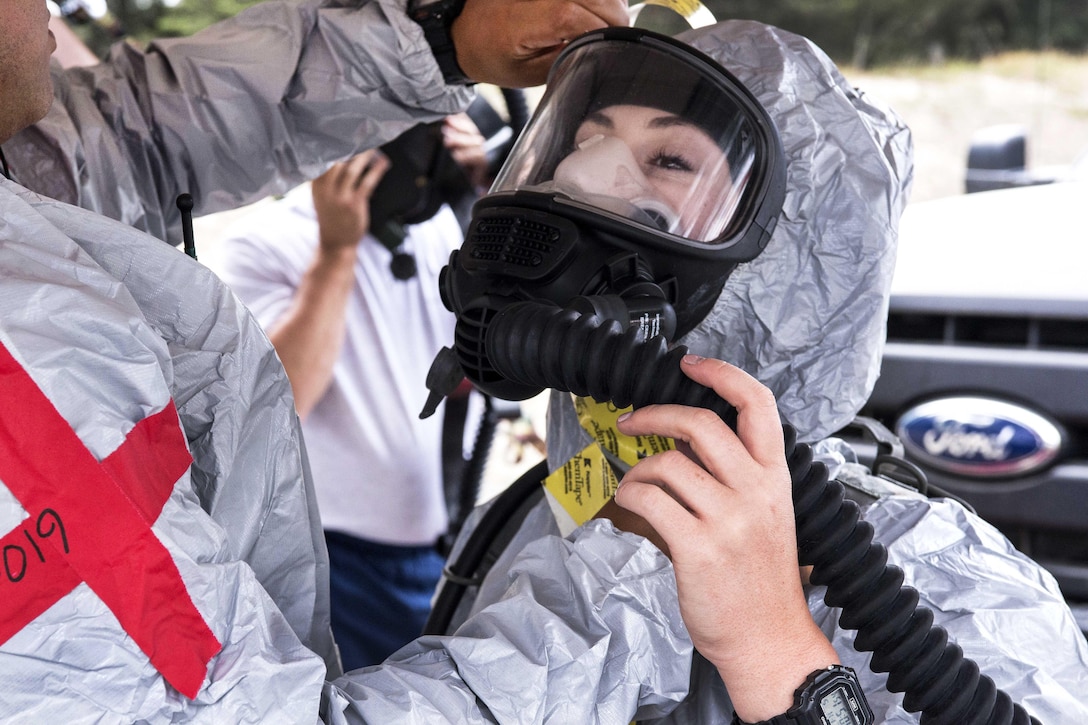 Senior Airman Emma M. Hinkle puts on her protective gear as she prepares to go into the hot zone during a joint exercise evaluation at Camp Rilea, Warrenton, Ore., Aug. 5, 2016. Hinkle is a hot triage medic assigned to the Colorado National Guard’s 140th Medical Group. Air National Guard photo by Staff Sgt. Bobbie Reynolds 