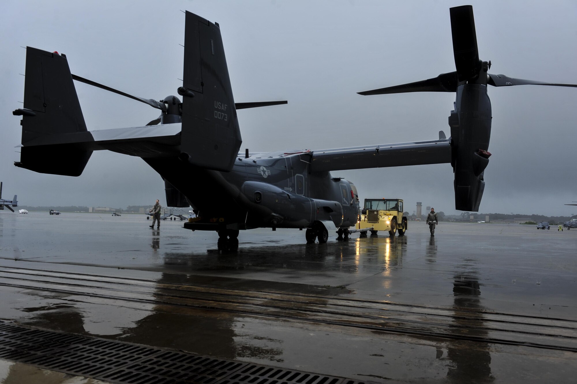 Crew chiefs with the 801st Special Operations Aircraft Maintenance Squadron tow a CV-22B Osprey tiltrotor aircraft into the Freedom Hangar at Hurlburt Field, Fla., Aug. 11, 2016. The Osprey combines vertical takeoff, hover and vertical landing capabilities of a helicopter with the long-range, fuel efficiency and speed characteristics of a turboprop aircraft. (U.S. Air Force photo by Airman Dennis Spain)