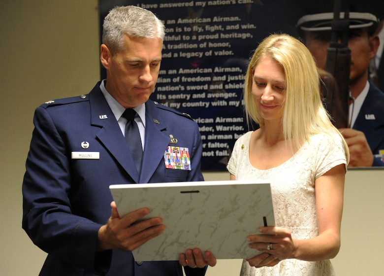 Lt. Col. Steven Mullins, 334th Training Squadron commander, presents Heather Gray Blalock, wife of the late Maj. W. David Gray, with a plaque during a room dedication ceremony to honor her late husband Aug. 8, 2016, on Keesler Air Force Base, Miss. Gray served for several years as an airfield operations officer and was killed in action in Afghanistan on Aug. 8, 2012. A tower lab training room was dedicated during the event. (U.S. Air Force photo by Kemberly Groue/Released)