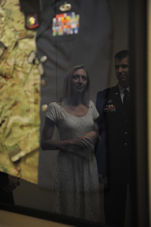 Heather Gray Blalock looks at a shadow box containing military uniforms of her late husband, Maj. W. David Gray, during a room dedication ceremony at Cody Hall , Aug. 8, 2016, on Keesler Air Force Base, Miss. Gray served for several years as an airfield operations officer and was killed in action in Afghanistan on Aug. 8, 2012. A tower lab training room was dedicated during the event. (U.S. Air Force photo by Kemberly Groue/Released)