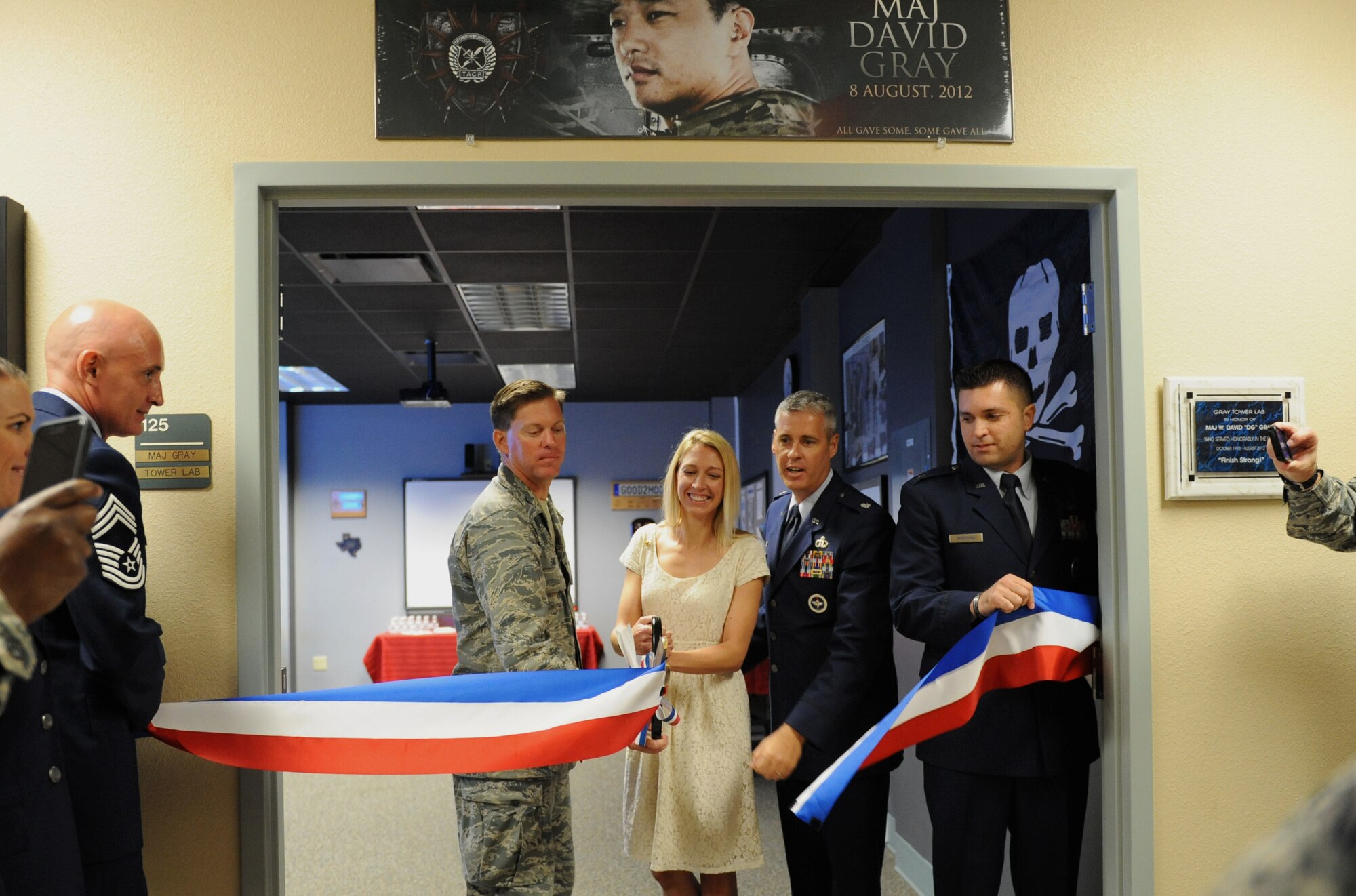 Col. C. Mike Smith, 81st Training Wing vice commander, Heather Gray Blalock, wife of the late Maj. W. David Gray, Lt. Col. Steven Mullins, 334th Training Squadron commander, and Capt. Gregory Birdsong, 334th TRS instructor supervisor, participate in a ribbon cutting ceremony at Cody Hall to honor Blalock’s late husband Aug. 8, 2016, on Keesler Air Force Base, Miss. Gray served for several years as an airfield operations officer and was killed in action in Afghanistan on Aug. 8, 2012. A tower lab training room was dedicated during the event. (U.S. Air Force photo by Kemberly Groue/Released)