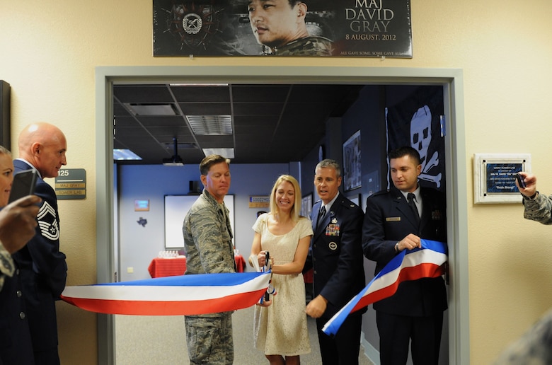 Col. C. Mike Smith, 81st Training Wing vice commander, Heather Gray Blalock, wife of the late Maj. W. David Gray, Lt. Col. Steven Mullins, 334th Training Squadron commander, and Capt. Gregory Birdsong, 334th TRS instructor supervisor, participate in a ribbon cutting ceremony at Cody Hall to honor Blalock’s late husband Aug. 8, 2016, on Keesler Air Force Base, Miss. Gray served for several years as an airfield operations officer and was killed in action in Afghanistan on Aug. 8, 2012. A tower lab training room was dedicated during the event. (U.S. Air Force photo by Kemberly Groue/Released)