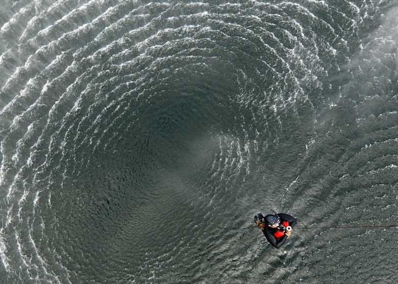 Tech. Sgt. Gary Waltz, a 306th Rescue Squadron SERE (survive, evade, resist, escape) specialist is hoisted from the waters of Lake Champlain, NY, Aug. 7. Two HH-60s and aircrew from the 305th Rescue Squadron​, Davis-Monthan Air Force Base, Arizona​, conducted training over the lake to ensure proficiency for pilots, special mission aviators and SERE specialists. (U.S. Air Force photo by Carolyn Herrick)