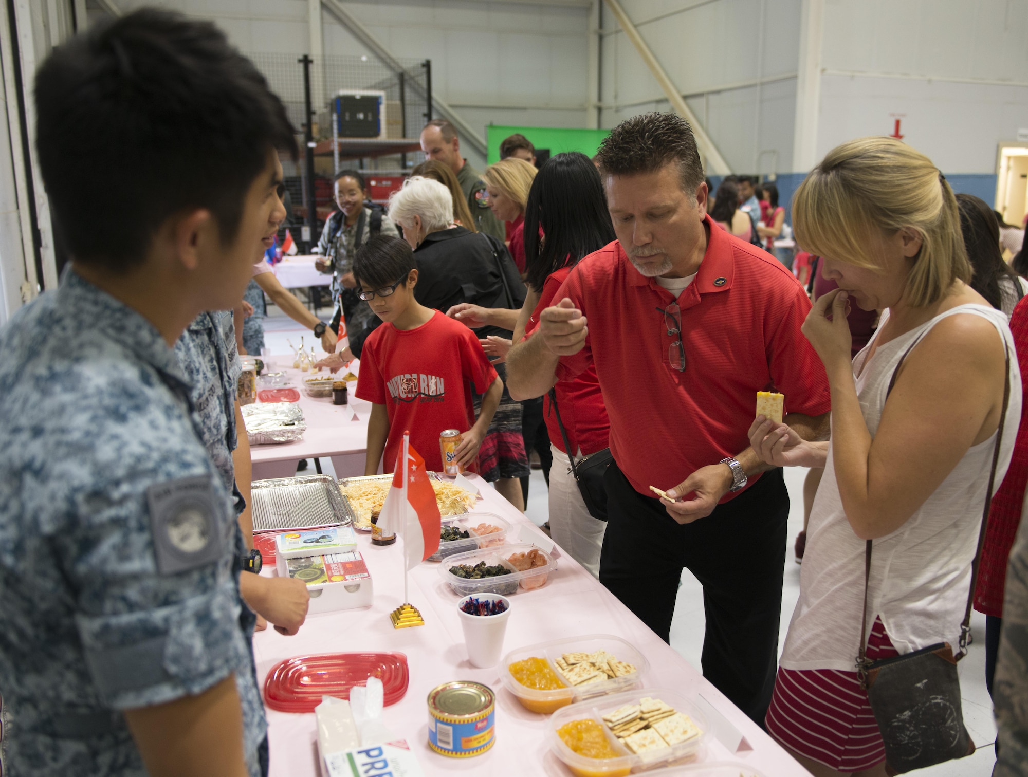 Volunteers serve various Singaporean foods to National Day celebration attendees August 5, 2016, at Mountain Home AFB, Idaho. Prior to a celebration dinner, Singaporean service members hosted several display booths where guests could play Singaporean games, sample authentic cuisine and learn about squadron accomplishments from the past year. (U.S. Air Force photo by 2nd Lt. Kippun Sumner/Released)
