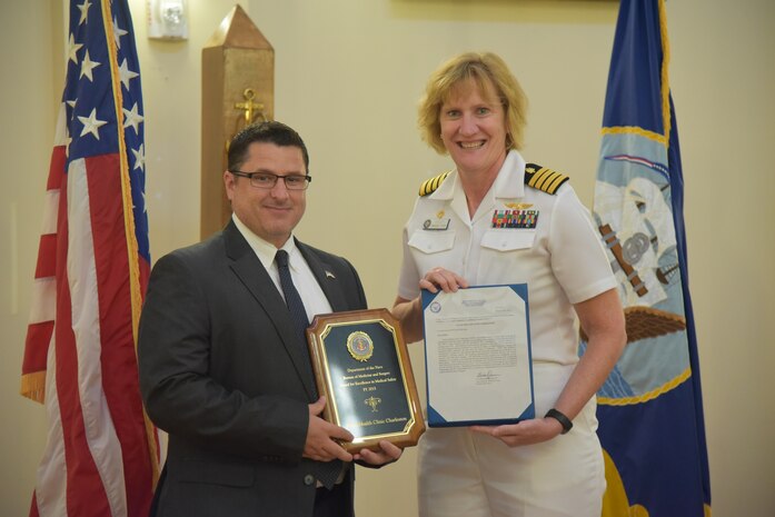 Cory VanDyke, safety officer for Naval Health Clinic Charleston, receives the 2015 Award for Excellence in Medical Safety from NHCC commanding officer Capt. Elizabeth Maley on behalf of the Department of the Navy Bureau of Medicine and Surgery Aug. 5, 2016  at NHCC, JB Charleston - WS. 