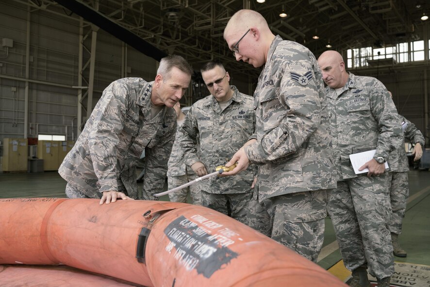 U.S. Air Force Senior Airman Zachary Cody, 374th Operations Support Squadron aircrew flight equipment journeyman, briefs Gen. Terrence J. O'Shaughnessy, Pacific Air Forces commander, about the specifications of life rafts at Yokota Air Base, Japan, Aug. 9, 2016. This was O'Shaughnessy’s first visit to Yokota as the commander of PACAF. (U.S. Air Force photo by Senior Airman Delano Scott)  