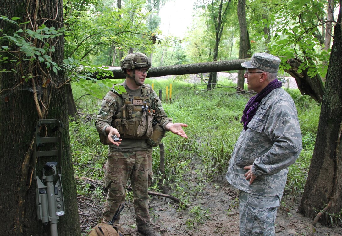 The 932nd Airlift Wing's Explosive Ordnance Disposal team spent extra time, beyond their normal drill weekend, preparing highly specialized equipment and then pushing themselves through the summer heat and humidity, deep into the forest during a rainstorm at Scott Air Force Base, in an effort to get additional skills training.  Tech. Sgt. Jeff Butera (left), explains his role during the muddy, mosquito and bug-infested event to Col. Jonathan Philebaum, the wing commander.  With rain soaking everyone's uniforms, and mud squishing beneath their boots, the technicians stayed hidden, communicated to each other, searched with mine sweepers, and got down on the ground in the mud to meticulously identify and remove improvised explosive devices August 13, 2016 in Illinois.  They are attached to 22nd Air Force, under Air Force Reserve Command.   (U.S. Air Force photo by Maj. Stan Paregien)
