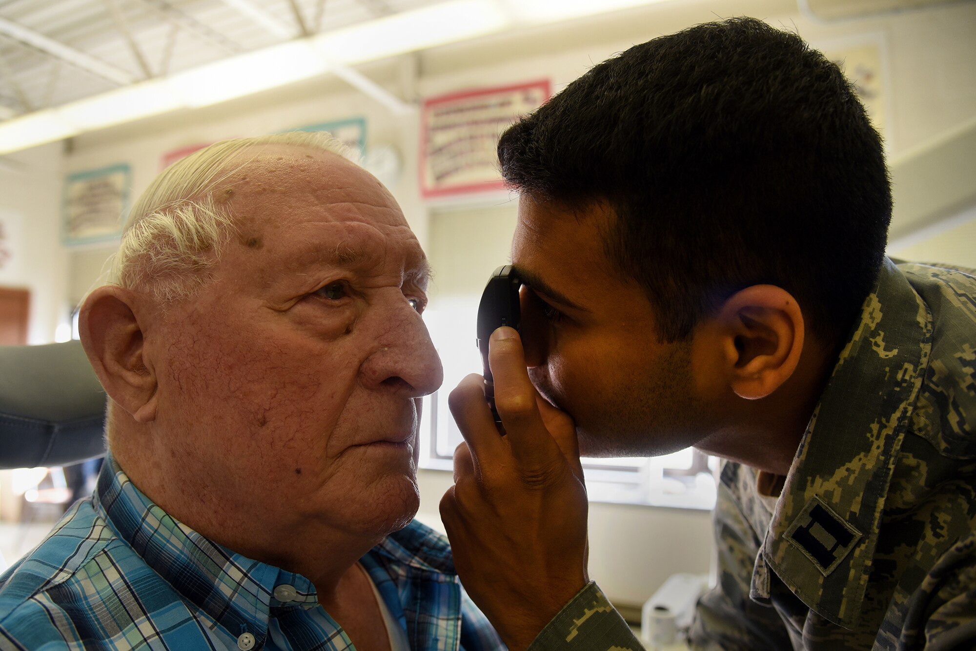 U.S. Air Force Capt. Saurin Patel, 108th Medical Group, checks Ira Holl's eyes to see what prescription he will need during the Healthy Cortland event at Homer Intermediate School in Homer, N.Y., July 19, 2016. Service members provided no cost medical, dental, optometry, and veterinary care to local citizens. (U.S. Air National Guard photo by Senior Airman Julia Santiago)