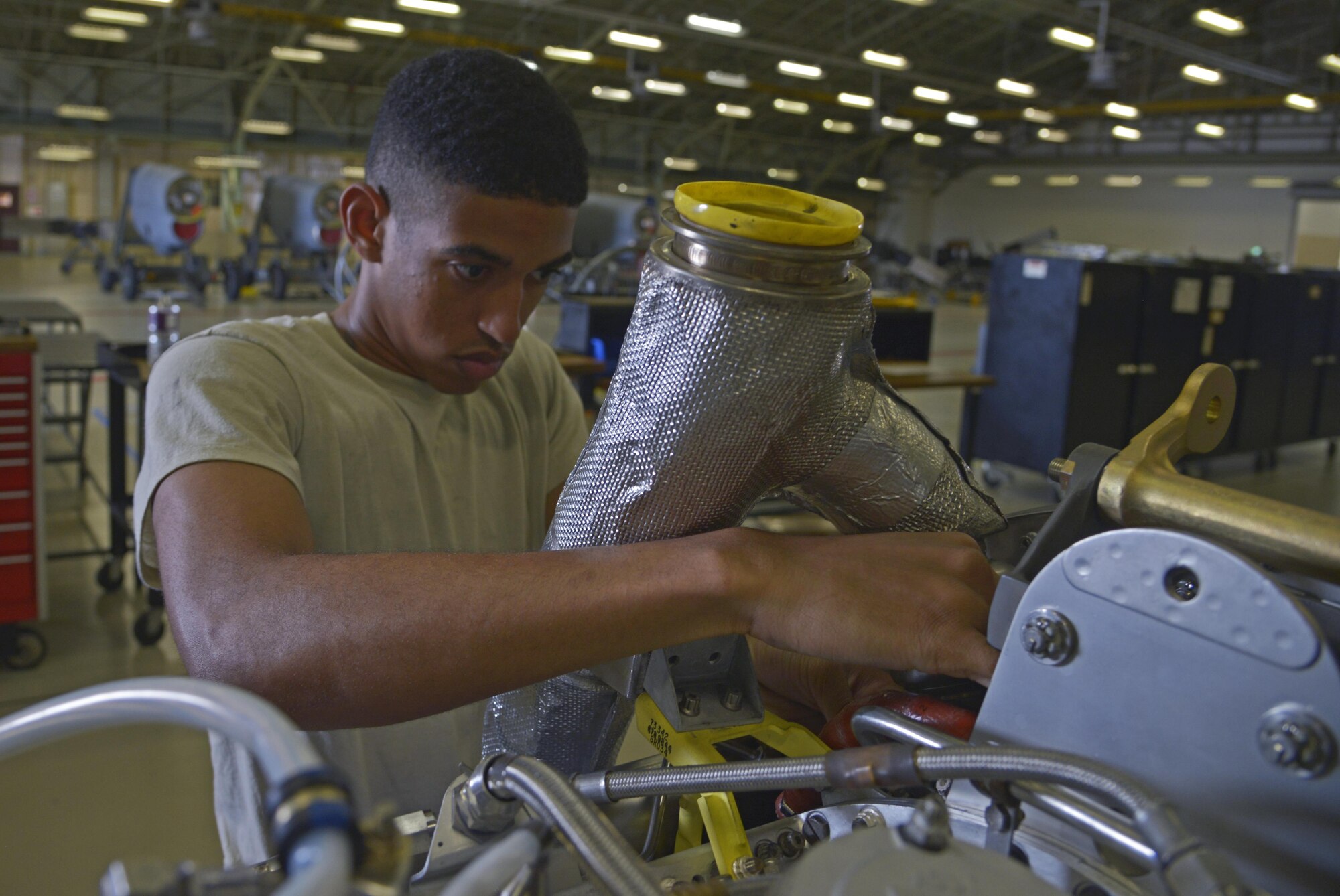 Airman 1st Class Trenton Dennis, 374th Maintenance Squadron aerospace propulsion flight apprentice, installs an upper lead duct onto a C-130 Hercules engine at Yokota Air Base, Japan, Aug. 11, 2016. The jet engine intermediate maintenance section performs routine maintenance work on the engines and, if necessary, is capable of rebuilding the entire engine.  (U.S. Air Force photo by Senior Airman David Owsianka/Released)