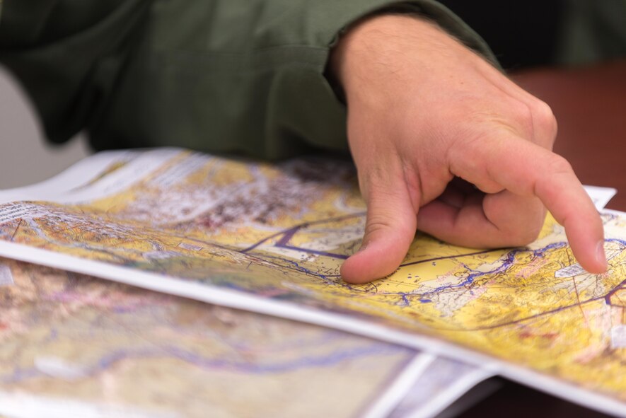 U.S. Air Force Capt. Andrew Huddleston, 36th Airlift Squadron C-130 Hercules pilot, points out a flight route at a pre-flight mission briefing during Red Flag-Alaska on Joint Base Elmendorf-Richardson, Alaska, Aug 6, 2016. During mission planning aircrew must go over routes, weather and potential simulated enemy forces to ensure the objective can be completed successfully. (U.S. Air Force photo by Staff Sgt. Michael Smith/Released)