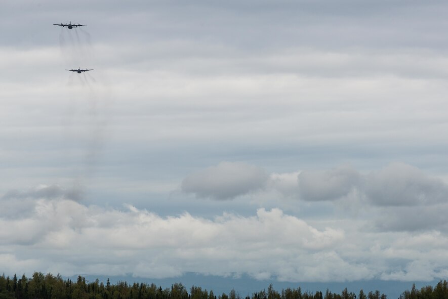 Two C-130 Hercules from Yokota Air Base begin to fly over the drop zone during Red Flag-Alaska at Joint Base Elmendorf-Richardson, Alaska, Aug 10, 2016. More than 20 allied countries have participated in Red Flag-Alaska since its conception, improving integration, interoperability and cross-cultural competence. (U.S. Air Force photo by Staff Sgt. Michael Smith/Released)