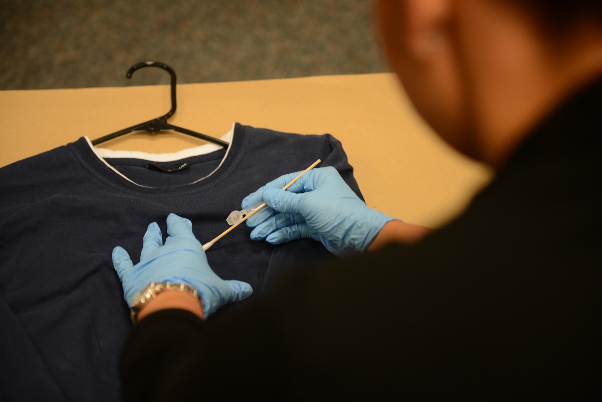 An Air Force Office of Special Investigations 13th Field Investigations Squadron agent demonstrates a presumptive blood test on a shirt Aug. 11, 2016, at Ramstein Air Base, Germany. A presumptive blood test is conducted to confirm whether or not blood is present on a piece of evidence. (U.S. Air Force photo/ Airman 1st Class Joshua Magbanua)