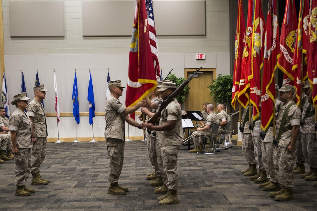 Sgt. Maj. William J. Grigsby (center), Sergeant Major of Force Headquarters Group, Marine Forces Reserve, takes the colors from the FHG color guard during the change of command ceremony at the Federal City Auditorium, New Orleans, Aug. 13, 2016. The passing of the colors symbolizes the transition from one commander to the other. (U.S. Marine Corps photo by Lance Cpl. Melissa Martens/ Released)