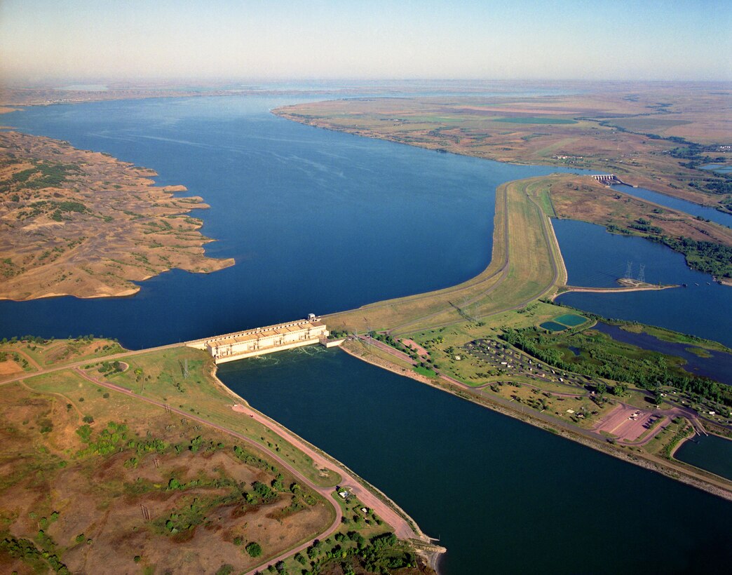 Big Bend Dam is located near Chamberlain, S.D., at River Mile 987.4. Although, the dam has a unique bend in its embankement, 
Big Bend Dam takes its name from the unique bend in the Missouri River seven miles upstream from the dam. At this point in its course, the Missouri makes almost a complete loop, traveling 25 miles before returning to the "neck" where the land is only about one mile wide. 