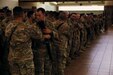 Soldiers with the 475th Eng. Co., both U.S. Army Reserve, switch the flag patch on their shoulders for the tactical one prior to boarding a flight to U.S. Central Command at the Silas L. Copeland Arrival/Departure Airfield Control Group here July 20.
