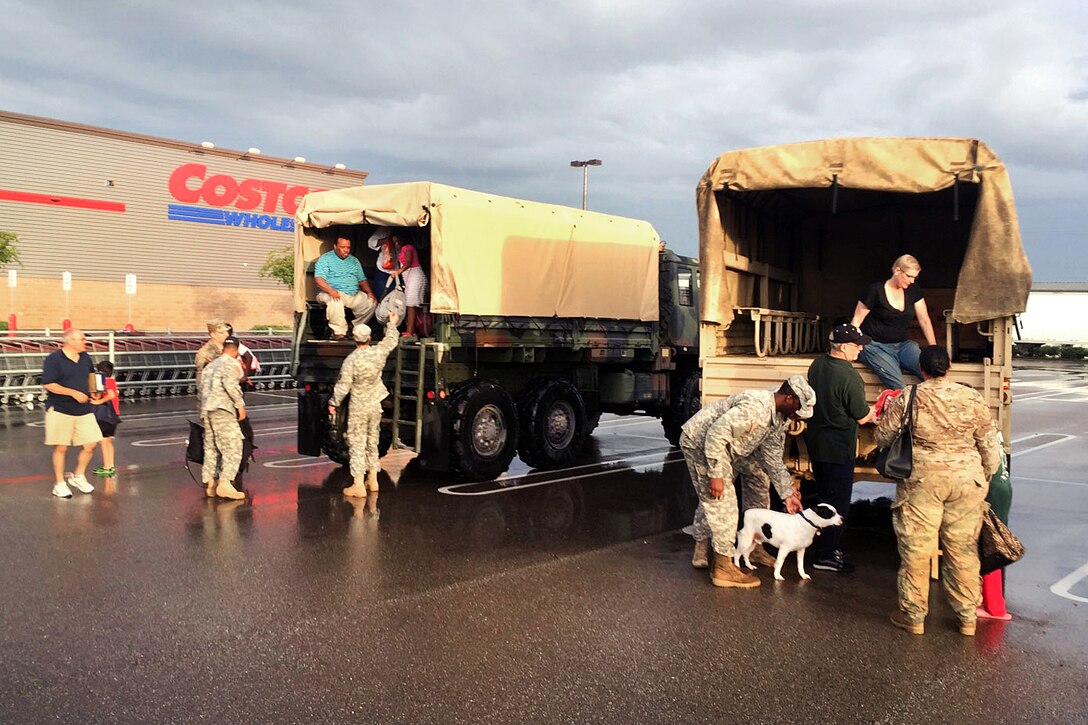Soldiers help displaced residents from a high-water vehicle following rescue operations amid severe flooding in Baton Rouge, La., Aug. 14, 2016. Guardsmen rescued more than 3,400 people and 400 pets withing 48 hours of the operation. Army National Guard photo by 1st Lt. Gomez    