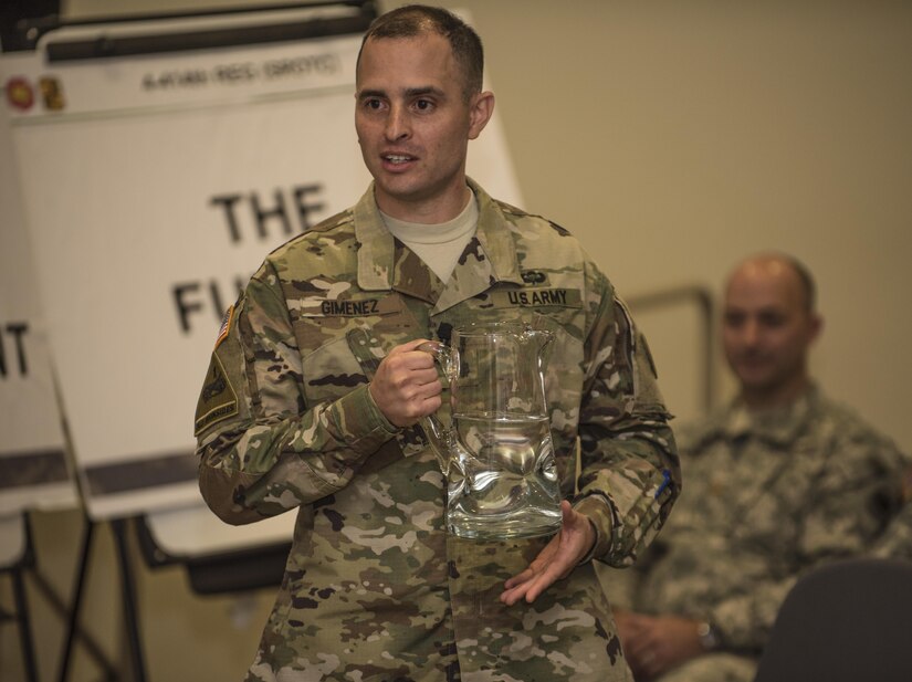 Lt. Col. Gregory Gimenez, 4th Battalion, 414th Regiment (SROTC), 104th Training Division (LT), battalion commander, uses a pitcher of water to demonstrate the fountain of youth and bring senior leaders back to points in their careers when they were junior commisioned and noncommissioned officers starting out in the Army Reserve during a senior leader seminar held at Joint Base Lewis McChord, Wash., Aug. 6. Sixty-seven Military Science Instructors from 150 Universities spread throughout 26 states were present during the seminar as part of an annual training development event designed to tap into senior leader mentoring and motivational techniques as well as provide a forum for the exchange of ideas and best practices. The event was hosted by the 104th Training Division's 4th Battalion, 414th Regiment (SROTC). (U.S. Army Reserve photo by Sgt. 1st Class Brian Hamilton)