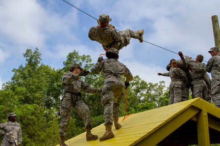 Field Leadership Reaction Course (FLRC) Senior Noncommissioned Officer in Charge, Sgt. 1st Class Electia Love, watches Task Force Wolf instructor, Army Reserve Staff Sgt. Kevin L. Fischer, mentor Cadet Initial Entry Training (CIET) candidates accomplishing obstacle 7, The Cliff-Hanger, during Cadet Summer Training (CST16), at Ft. Knox, Kentucky June 16. (U.S. Army Reserve photo by Sgt. Karen Sampson/ Released)