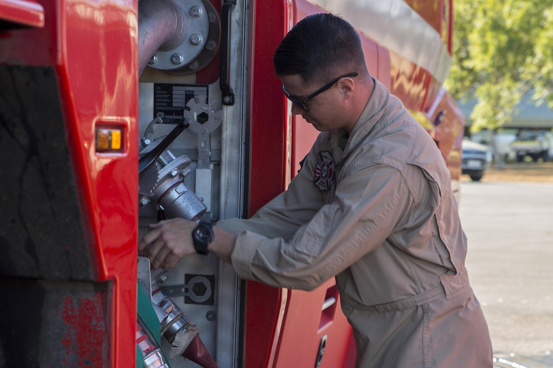 U.S. Marine Corps Cpl. Michael Barton, an aircraft rescue firefighter specialist with Marine Wing Support Squadron 171, refills a firetruck during Exercise Pitch Black 2016 at Royal Australian Air Force Base Tindal, Australia, July 28, 2016. Marine Corps photo by Cpl. Nicole Zurbrugg