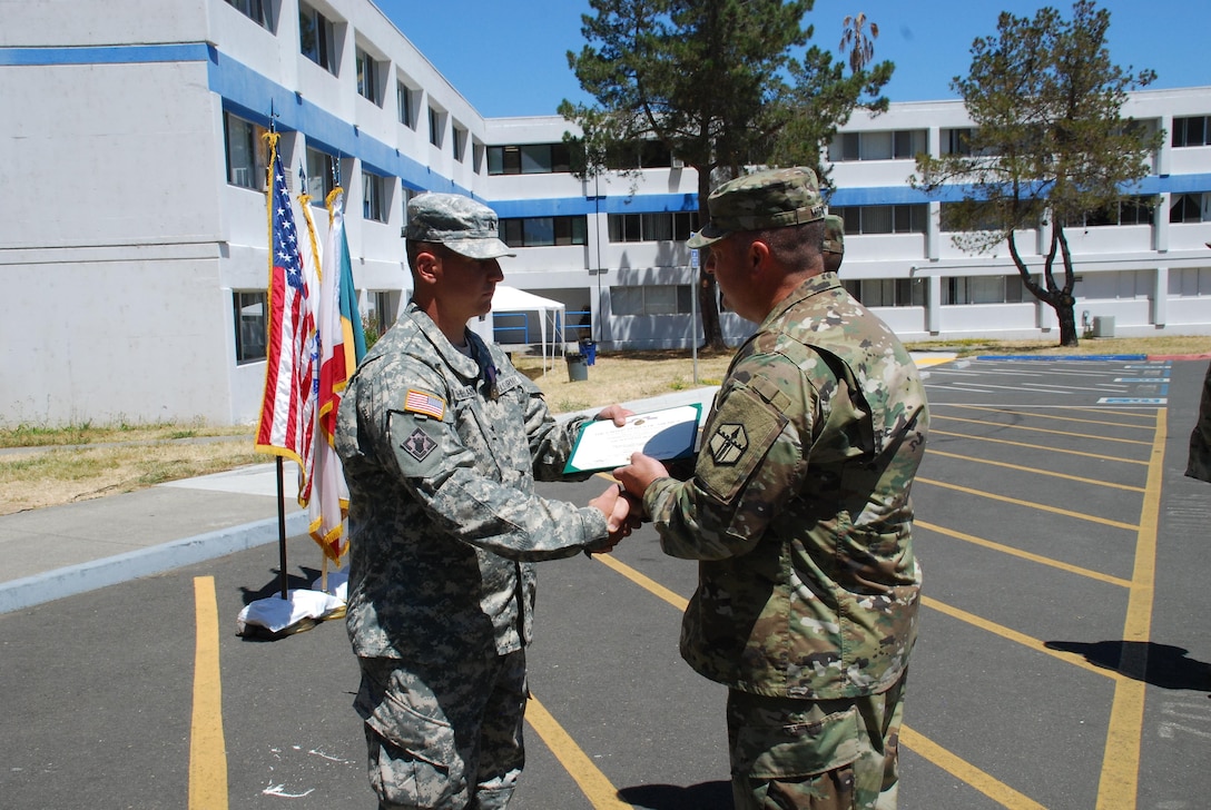 Sgt. Logan Sutherland is handed the Soldier’s Medal award certificate, in Vallejo, Calif., by Col. William Morgan Jr. Sutherland, a horizontal construction engineer assigned to 801st EN CO (H), 315th EN BN, 301st MEB, on Jan. 1, 2015, risked his life by forcing himself into a burning vehicle, in order to evacuate an unconscious driver, and pulled the driver from the vehicle just before the vehicle became fully engulfed in flames, saving the driver’s life. (U.S. Army photo by Sgt. Timothy Neal/Released)