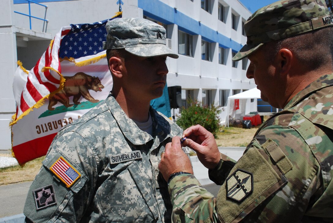 Col. William Morgan Jr., commander of the 301st Maneuver Enhancement Brigade, decorates Sgt. Logan Sutherland with the Soldier’s Medal, Aug. 7, 2016, in Vallejo Calif. Sutherland, a horizontal construction engineer assigned to 801st EN CO (H), 315th EN BN, 301st MEB, on Jan. 1, 2015, risked his life by forcing himself into a burning vehicle, in order to evacuate an unconscious driver, and pulled the driver from the vehicle just before the vehicle became fully engulfed in flames, saving the driver’s life. (U.S. Army photo by Sgt. Timothy Neal/Released)