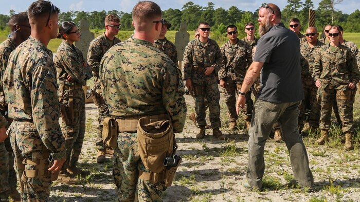 A Department of Defense marksmanship instructor teaches Marines with 2nd Law Enforcement Battalion about combat situations with the Beretta M9 pistol during a weeklong weapon training exercise at Marine Corps Base Camp Lejeune, N.C., August 9, 2016. Marines are shown how to perform certain drills to maximize efficiency of covering the 360 degree threat.