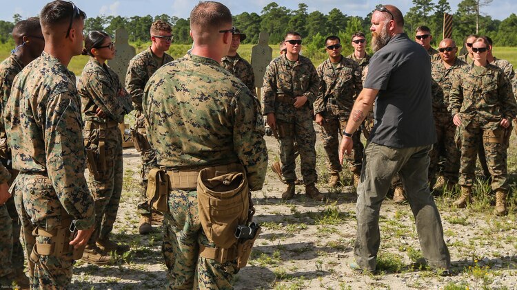 A Department of Defense marksmanship instructor teaches Marines with 2nd Law Enforcement Battalion about combat situations with the Beretta M9 pistol during a weeklong weapon training exercise at Marine Corps Base Camp Lejeune, N.C., August 9, 2016. Marines are shown how to perform certain drills to maximize efficiency of covering the 360 degree threat.
