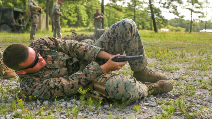 Lance Cpl. David W. Huston Jr., a military policeman with 2nd Law Enforcement Battalion discharges a Beretta M9 pistol while lying on his side during a weeklong weapon training exercise at Marine Corps Base Camp Lejeune, N.C., August 9, 2016. Marines practiced firing pistols in several unconventional style drills, helping enhance their confidence, knowledge and skills with the weapon. 