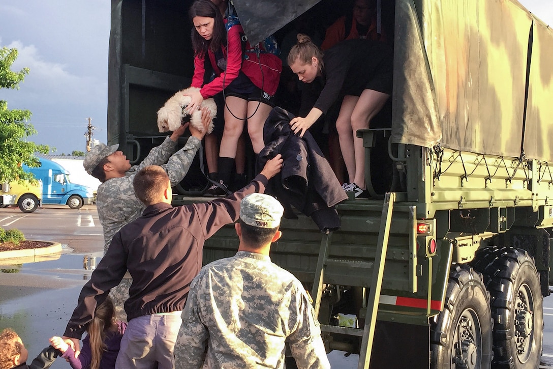 Soldiers help rescued residents from a high-water vehicle after severe flooding in Baton Rouge, La., Aug. 14, 2016. Guardsmen have rescued more than 3,400 people and 400 pets since operations began Aug. 12. Army National Guard photo by 1st Lt. Gomez