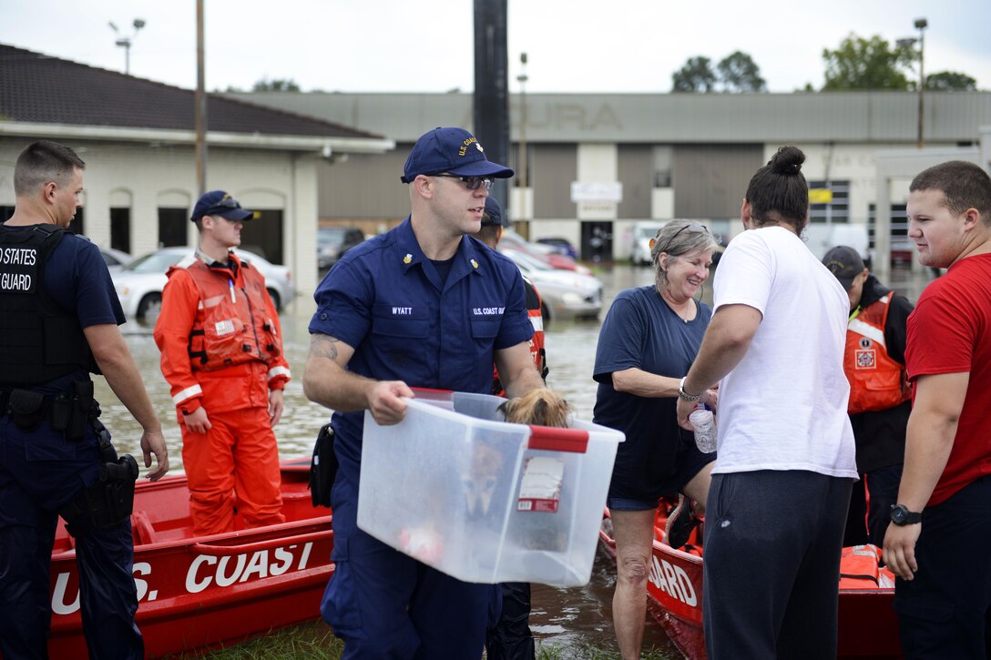 Coast Guard Petty Officer 1st Class Iredell Wyatt helps stranded residents and their pets during severe flooding around Baton Rouge, La., Aug. 14, 2016. Coast Guard photo by Petty Officer 3rd Class Brandon Giles