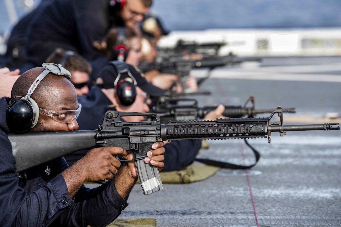 Navy Petty Officer 1st Class Julius Perry fires an M16 rifle during a small arms qualification on the flight deck of the amphibious transport dock ship USS Green Bay in the East China Sea, Aug. 10, 2016.  The Green Bay is supporting security and stability in the Indo-Asia-Pacific region. Perry is an operations specialist. Navy photo by Petty Officer 1st Class Chris Williamson