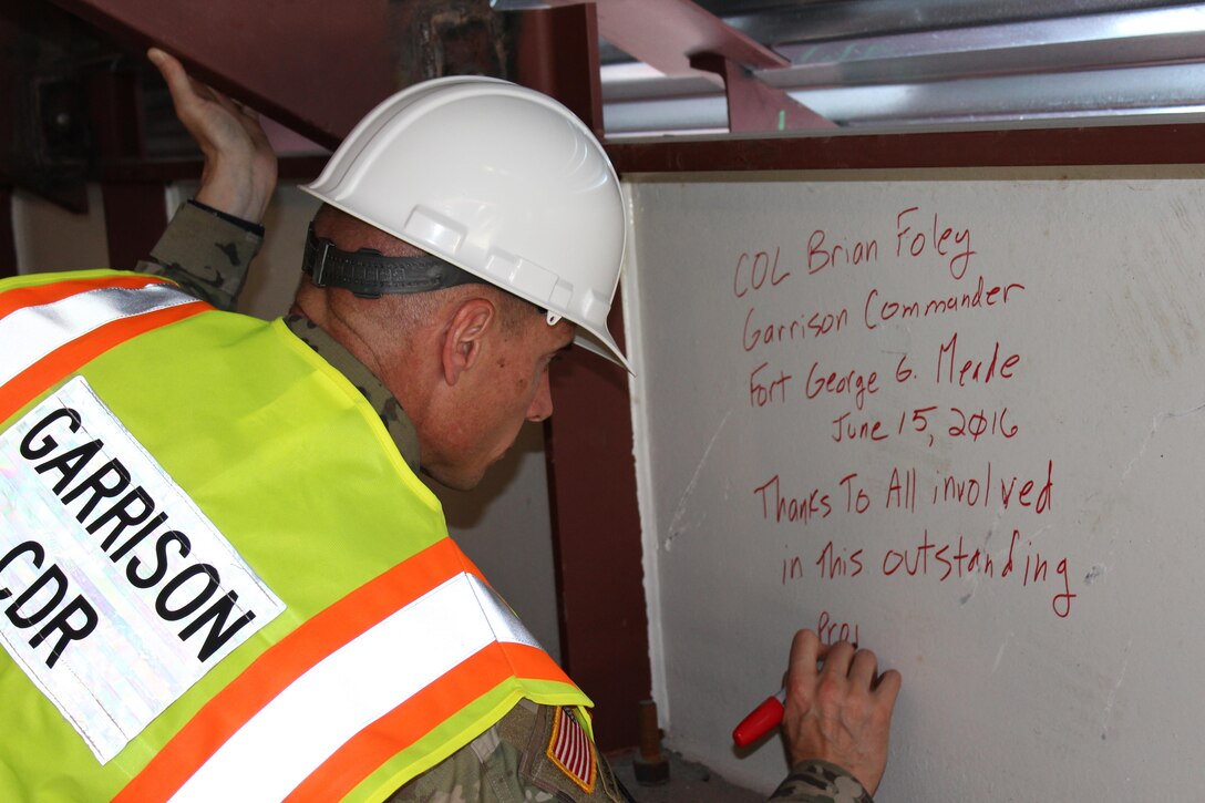 Fort Meade Garrison Commander Col. Tom Foley signs the top piece of steel in the renovation project at building 4554.