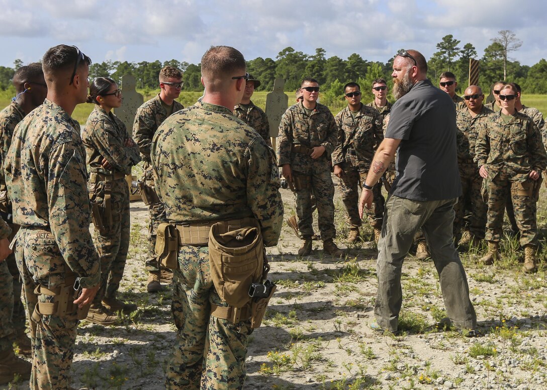 A Department of Defense marksmanship instructor teaches Marines with 2nd Law Enforcement Battalion about combat situations with the Beretta M9 pistol during a weeklong weapon training exercise at Camp Lejeune, N.C., August 9. Marines are shown how to perform certain drills to maximize efficiency of covering the 360 degree threat. (U.S. Marine Corps photo by Lance Cpl. Aaron K. Fiala)