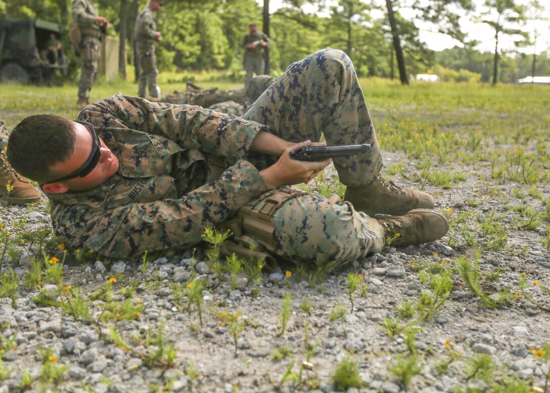 Lance Cpl. David W. Huston Jr., a military policeman with 2nd Law Enforcement Battalion discharges a Beretta M9 pistol while lying on his side during a weeklong weapon training exercise at Camp Lejeune, N.C., August 9. Marines practiced firing pistols in several unconventional style drills, helping enhance their confidence, knowledge and skills with the weapon. (U.S. Marine Corps photo by Lance Cpl. Aaron K. Fiala)