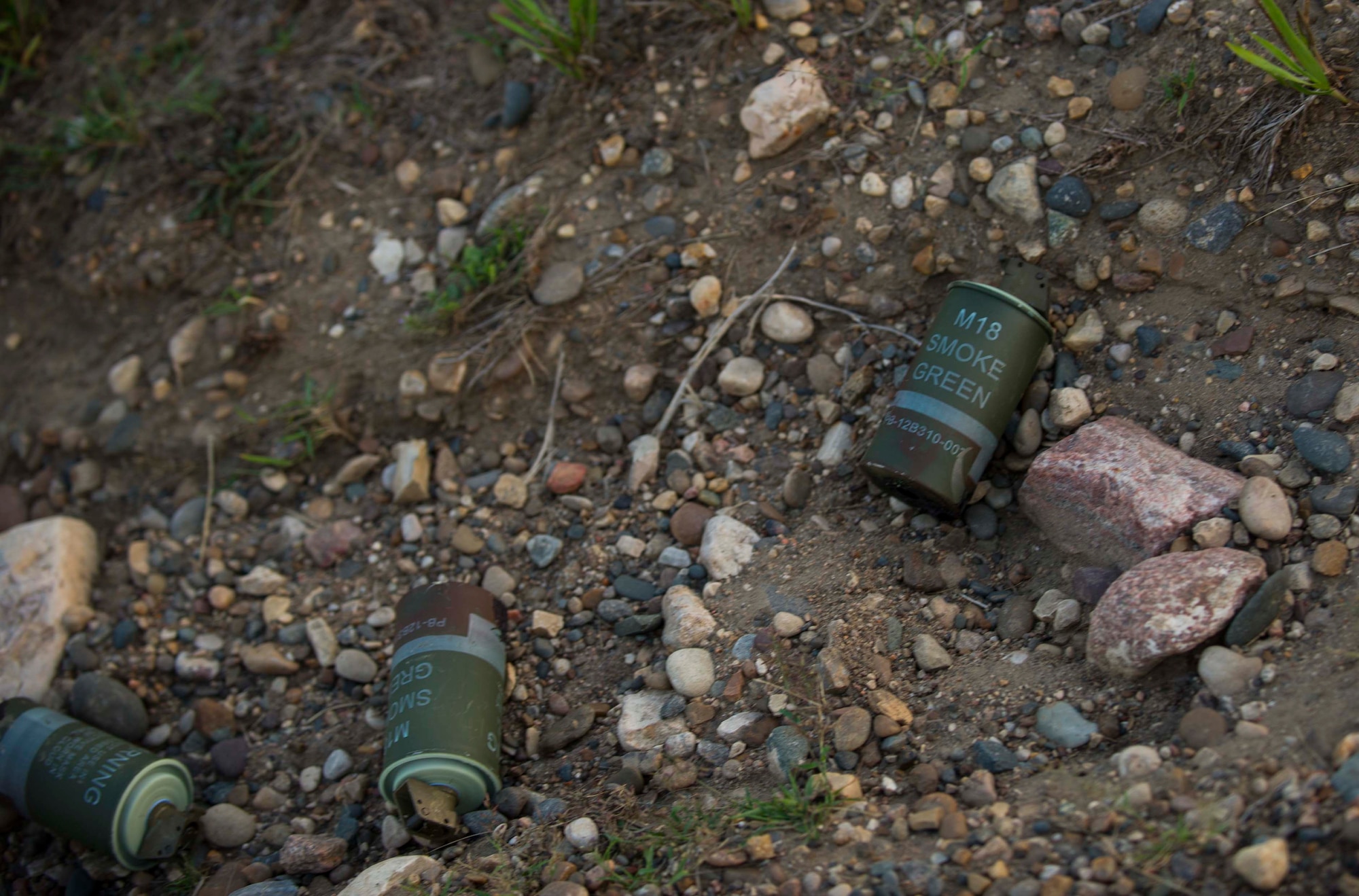 Used smoke cans lay in the exercise area during survival, evasion, resistance and escape training in Garrison, N.D., Aug. 11, 2016. Colored smoke is used in exercises to simulate certain incidents. (U.S. Air Force photo/Senior Airman Apryl Hall)
