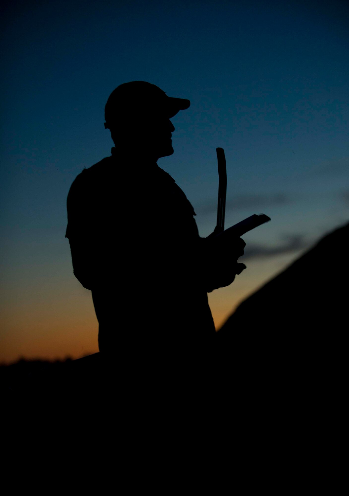 Tech. Sgt. Clifton Cleveland, 5th Operations Support Squadron survival, evasion, resistance and escape specialist, communicates with a group of lost Airmen during SERE training in Garrison, N.D., Aug. 11, 2016. The groups were scattered throughout the site and then instructed to use their survival skills to reach their rescuers. (U.S. Air Force photo/Senior Airman Apryl Hall)