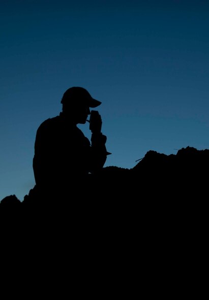 Tech. Sgt. Clifton Cleveland, 5th Operations Support Squadron survival, evasion, resistance and escape specialist, communicates with a group of lost Airmen during SERE training in Garrison, N.D., Aug. 11, 2016. The groups were scattered throughout the site and then instructed to use their survival skills to reach their rescuers. (U.S. Air Force photo/Senior Airman Apryl Hall)