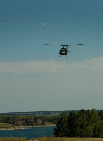 Aircrew in a UH-1N Iroquois scans the land during vector training in Garrison, N.D., Aug. 11, 2016. The Huey crew was vectored in by Airmen on the ground portraying a search and rescue scenario. (U.S. Air Force photo/Senior Airman Apryl Hall)