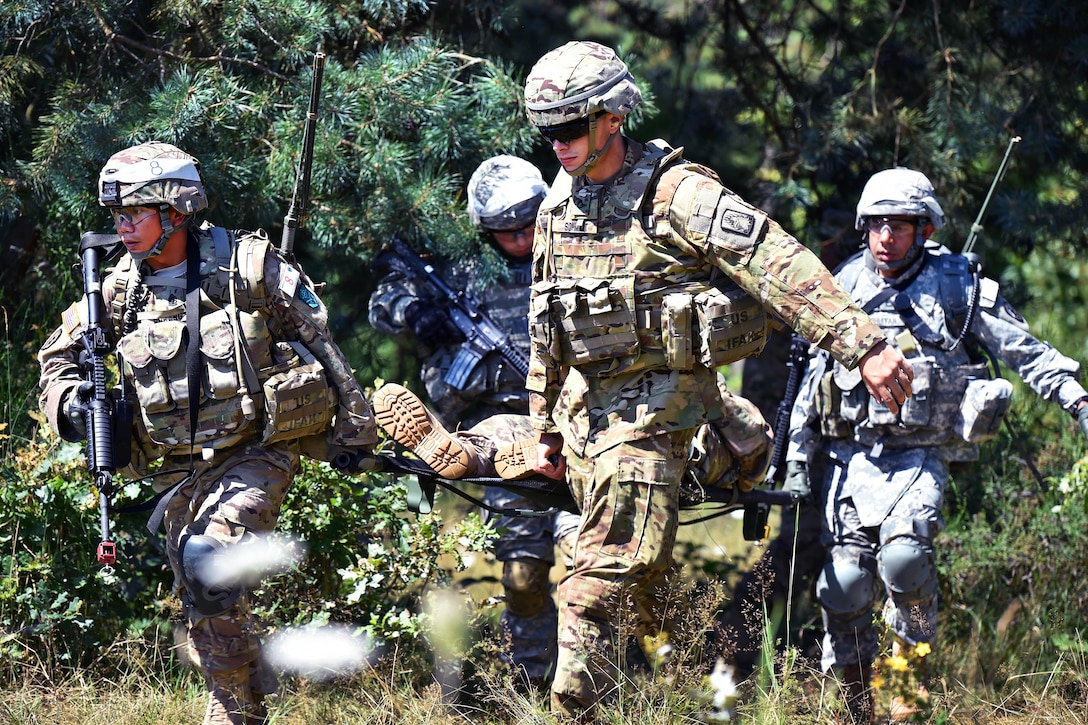 Army Sgt. 1st Class Dominador Rubang, left, Pfc Schmidt, right, and Staff Sgts. Jeremiah Steele and Mohammad Bhuiyan carry a simulated casualty during the 2016 European Best Warrior Competition at the 7th Army Training Command's Grafenwoehr Training Area, Germany, Aug. 8, 2016. Rubang is assigned to the U.S. Army NATO Brigade, Steele is assigned to U.S. Army Africa and Bhuiyan is assigned to the 650th Military Intelligence Group. Army photo by Gertrud Zach