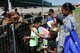 Tech. Sgt. Cassandra Burrows, a Career Development Technician for the 910th Force Support Squadron watches her daughter, Lyric, feed a camel during the annual 910th Family Day here, August 7, 2016. (U.S. Air Force photo/Tech. Sgt. James Brock)