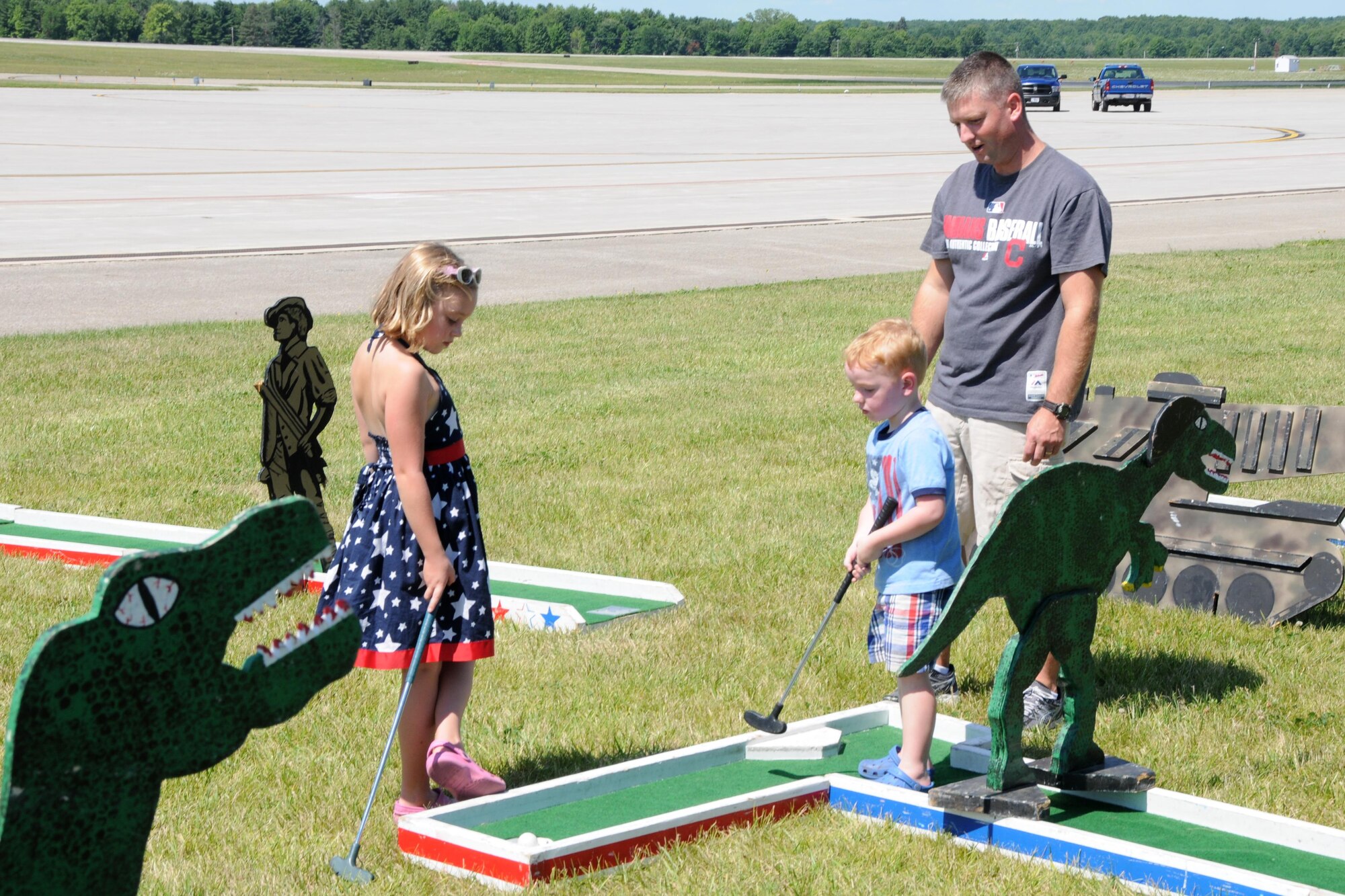 Master Sgt. Nathan Anderson a C-130 Crew Chief with the 910th Maintenance Squadron plays a game of miniature golf with his son Owen, and daughter, Molly, during Family Day here, August 7, 2016. . (U.S. Air Force photo/Tech. Sgt. James Brock)