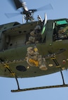 A Minot Airman is hoisted up into a UH-1N Iroquois helicopter during a training exercise at Garrison, N.D., Aug. 11, 2016. During the training, several different squadrons paired with survive, evasion, resistance and escape specialist to practice helicopter hoisting, land navigation, evade and recovery and other SERE-based events. (U.S. Air Force photo/Airman 1st Class Christian Sullivan)