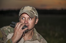Tech. Sgt. Clifton Cleveland, 5th Operations Support Squadron survive, evasion, resistance and escape specialist, talks over the radio during a training event in Garrison, N.D., Aug. 11, 2016. Approximately 15 Airmen spent roughly 10 hours in an outdoor setting to practice survival techniques such as setting up communications, building fires and other survival techniques. (U.S. Air Force photo/Airman 1st Class Christian Sullivan)
