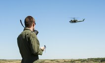 A Minot Airman vectors a mock rescue Huey during an exercise at a training facility at Garrison, N.D., Aug. 11, 2016. Squadrons such as the 5th OSS focus a majority of their training on teaching survival techniques to prepare Airmen for situations where they may need to seek rescue. (U.S. Air Force photo/Airman 1st Class Christian Sullivan)